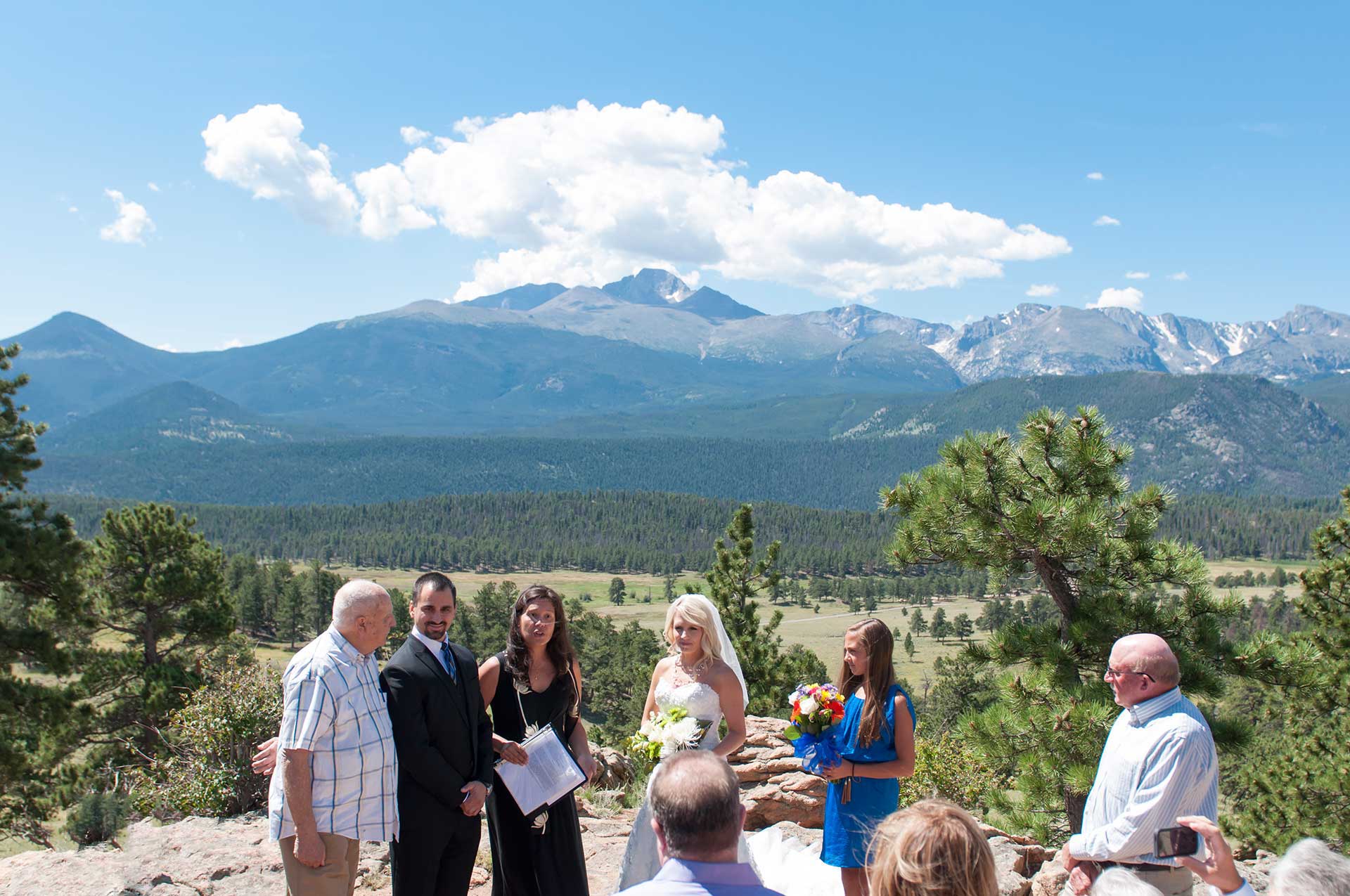 the wedding party standing with the mountains in the background
